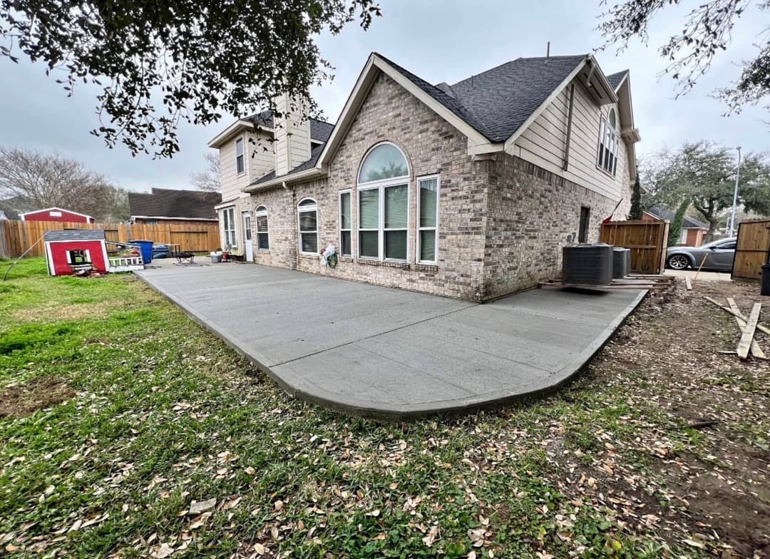 Home exterior featuring a newly poured concrete patio and landscaped yard.